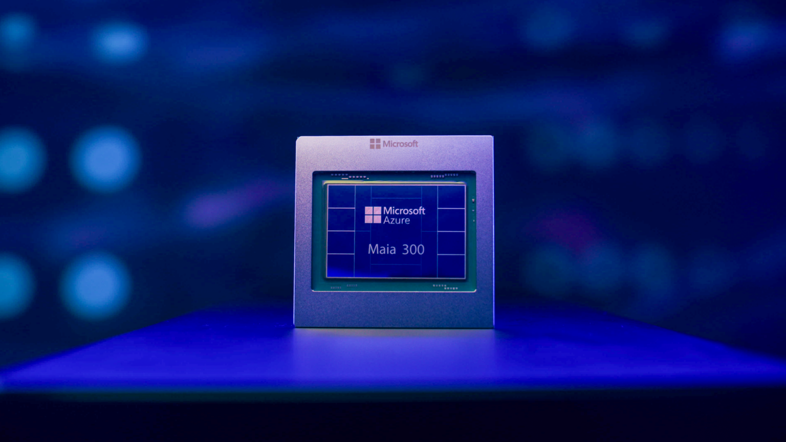 The official Microsoft hero photograph for Maia 300, showing the accelerator package in a carrier on a blue-lit surface.