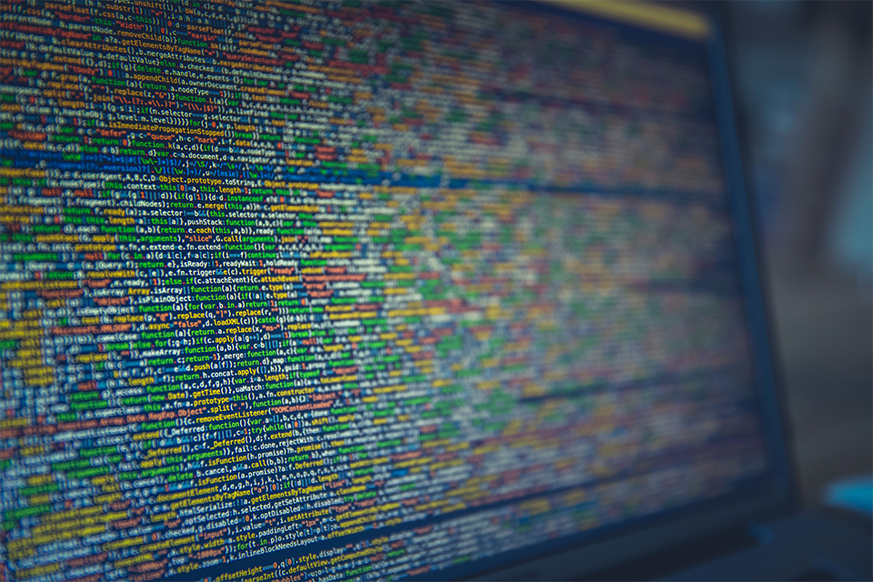 The official artwork published with the GOV.UK case study, a photograph of indented source code on a screen in green, amber and blue.